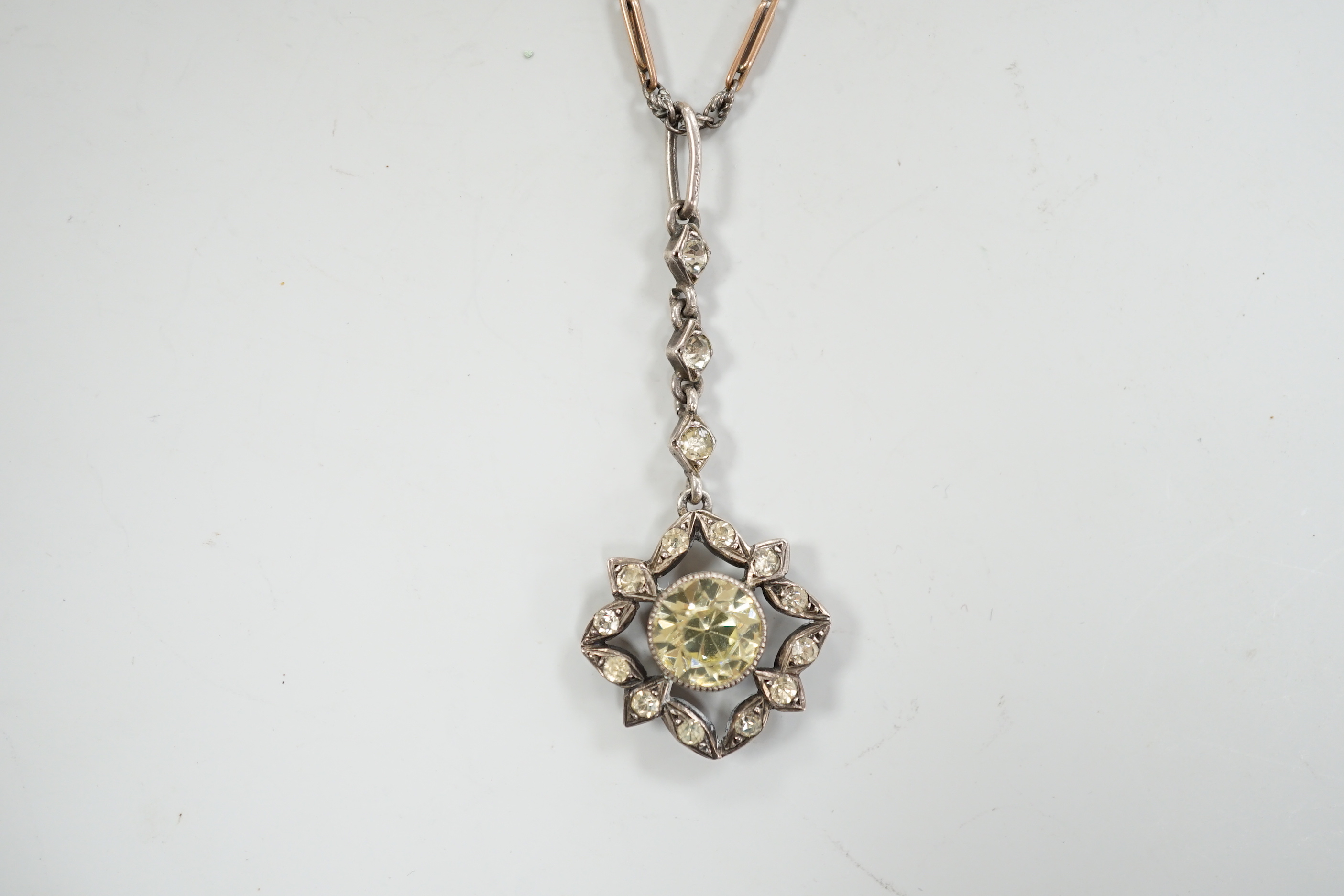 A 19th century white metal and foil backed paste set pendant, 40mm, on a later two colour chain, the clasp stamped 9ct.